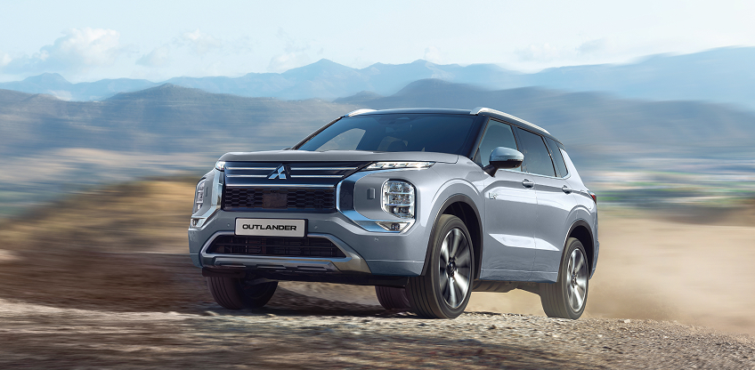 Ein grauer Mitsubishi Outlander f&auml;hrt durchs Gel&auml;nde.