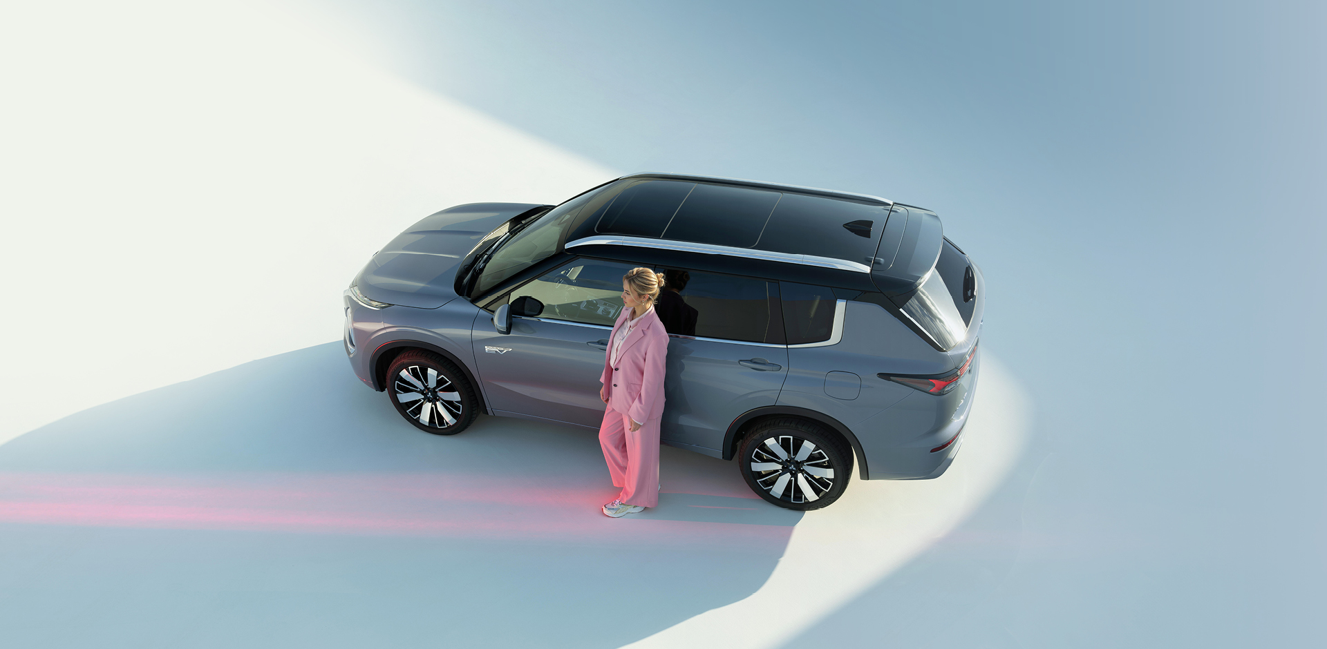 Frau lehnt an der Fahrert&uuml;r des Outlanders