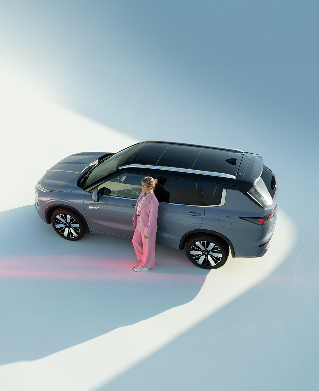 Frau lehnt an der Fahrert&uuml;r des Outlanders