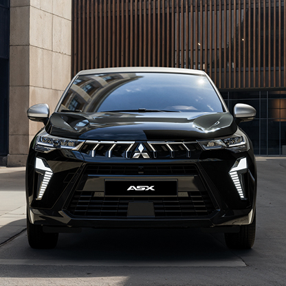 Schwarzer Mitsubishi ASX Black in der Frontansicht vor einem modernen Geb&auml;ude mit Holzfassade 