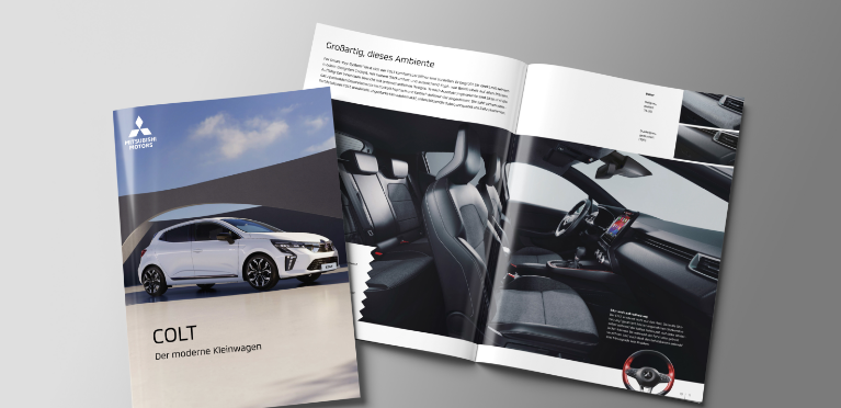 Die aufgebl&auml;tterte Brosch&uuml;re des COLT liegt auf grauem Untergrund.