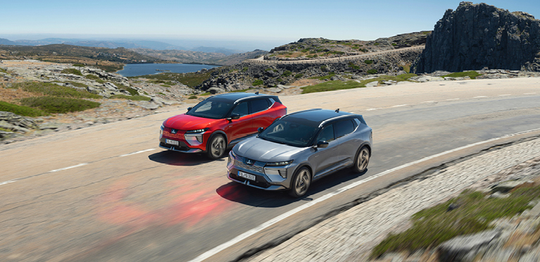 Zwei Mitsubishi Eclipse Cross fahren eine K&uuml;stenstra&szlig;e entlang.