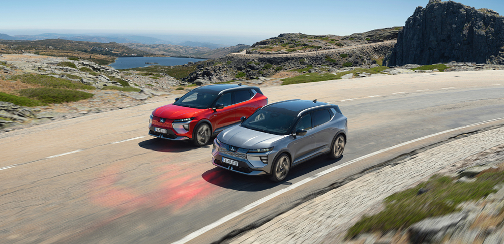 Zwei Mitsubishi Eclipse Cross fahren eine K&uuml;stenstra&szlig;e entlang.