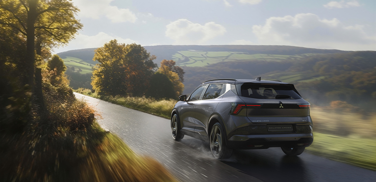 Der neue Mitsubishi Eclipse Cross f&auml;hrt eine Landstra&szlig;e entlang.