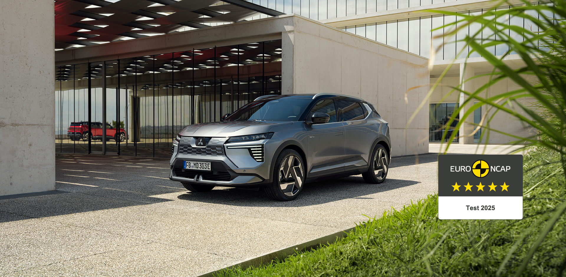 Der neue Mitsubishi Eclipse Cross steht vor einer Galerie, rechts daneben das 5-Sterne-Euro NCAP-Logo.