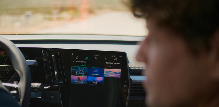 Ein Mann schaut vom Beifahrersitz nach links, im Hintergrund ist das Infotainment des neuen Mitsubishi Eclipse Cross zu sehen.