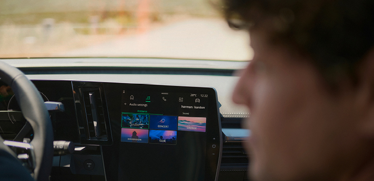 Ein Mann schaut vom Beifahrersitz nach links, im Hintergrund ist das Infotainment des neuen Mitsubishi Eclipse Cross zu sehen.