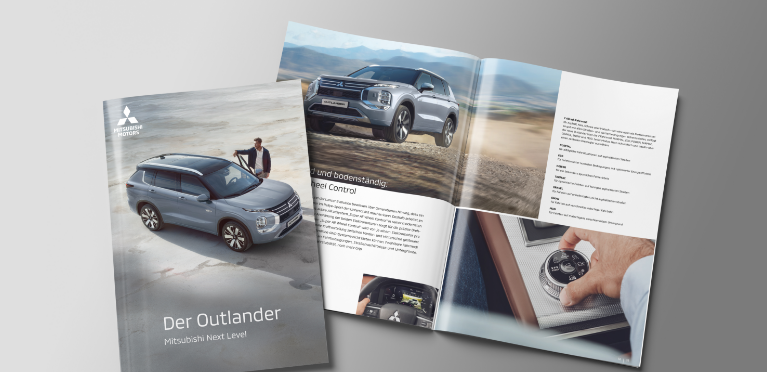 Die aufgebl&auml;tterte Brosch&uuml;re des Outlander liegt auf grauem Untergrund.