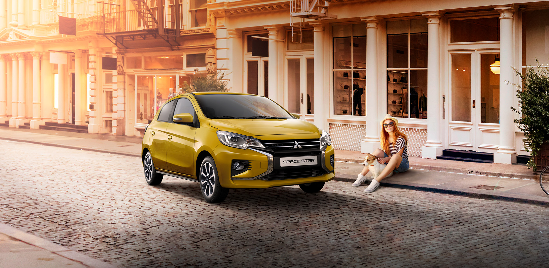 Mitsubishi Space Star Frau mit Hund sitzt am Straßenrand neben einem parkenden Space Star