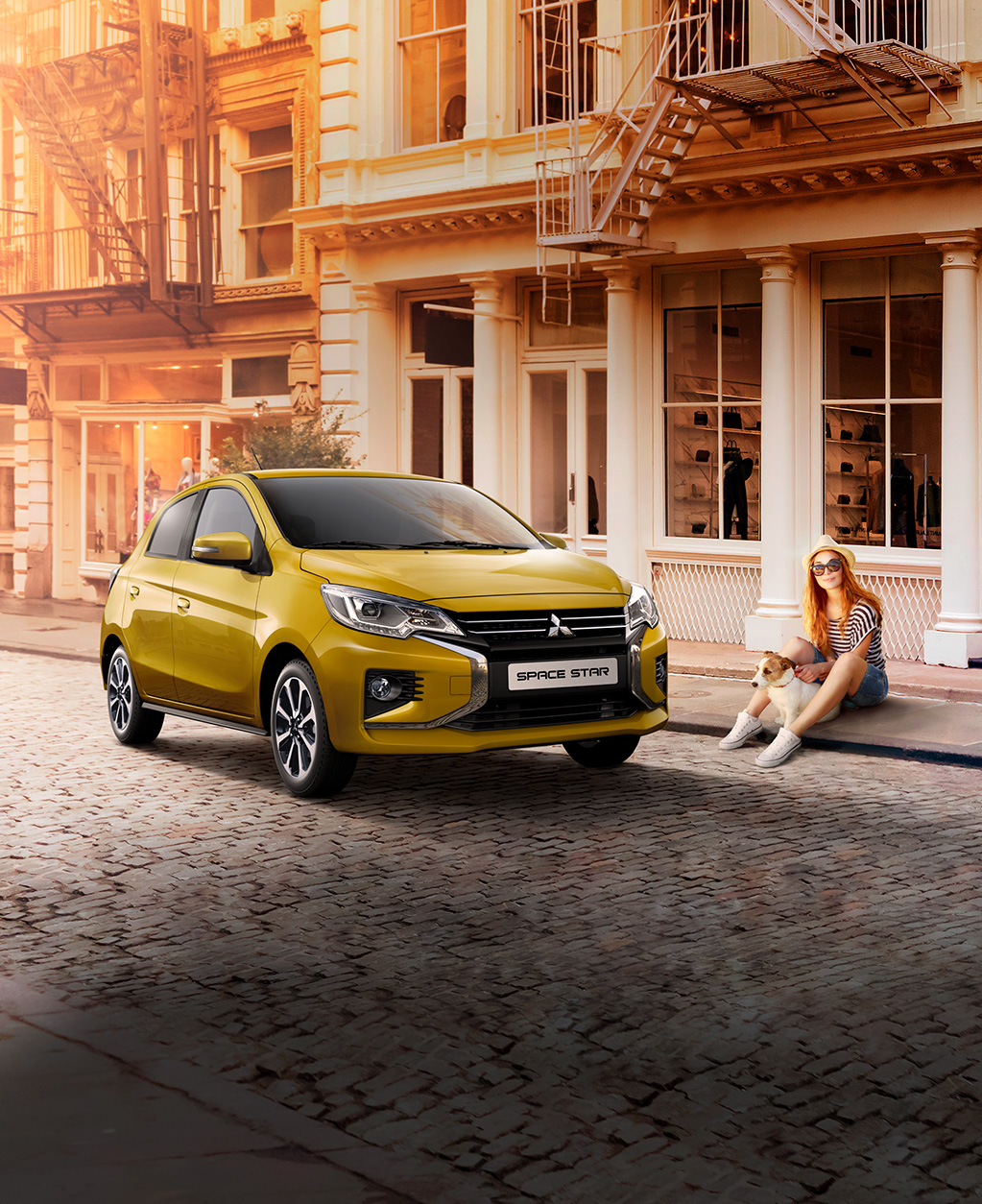 Mitsubishi Space Star Frau mit Hund sitzt am Straßenrand neben einem parkenden Space Star