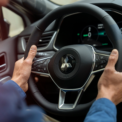 Herstellergarantien Männliche Hände umfassen das Lenkrad eines Mitsubishi