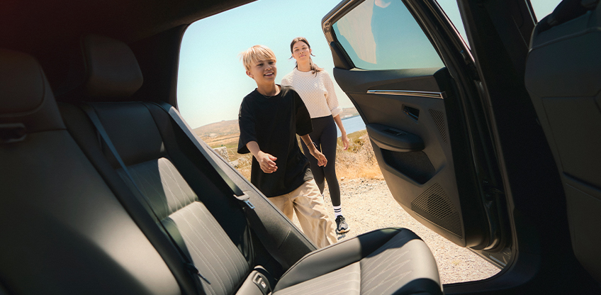 Mutter und Sohn steigen auf der Fahrerseite durch die Hintert&uuml;r in den Mitsubishi Eclipse Cross.