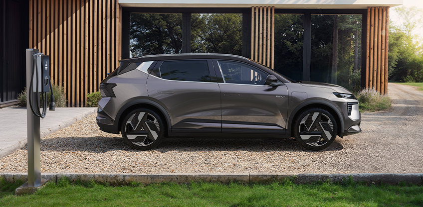 Der Mitsubishi Eclipse Cross steht an einer Wallbox vor einem modernen Geb&auml;ude.