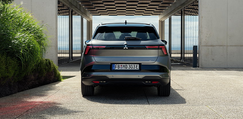 Heckansicht des Eclipse Cross vor modernem Geb&auml;ude 