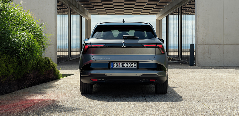 Heckansicht des Eclipse Cross vor modernem Geb&auml;ude 