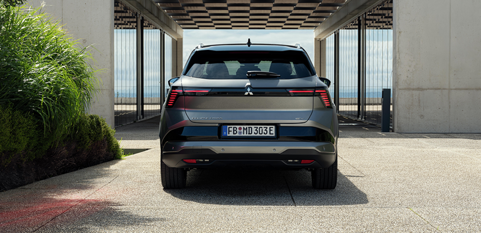 Heckansicht des Eclipse Cross vor modernem Geb&auml;ude 