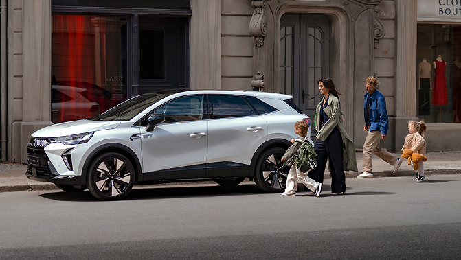 Eine vierk&ouml;pfige Familie l&auml;uft auf den am Stra&szlig;enrand geparkten Grandis zu.